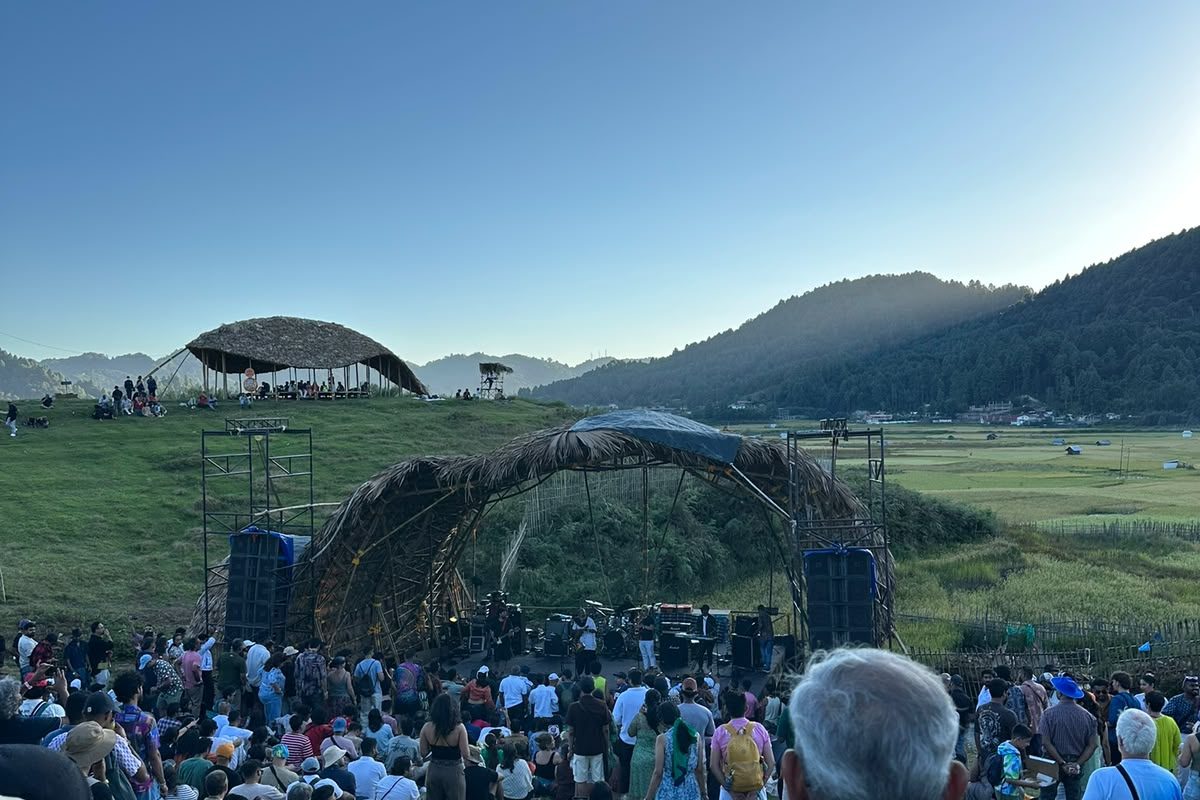 Crowd gathered at the Ziro Festival amphitheatre at dawn, mountains behind